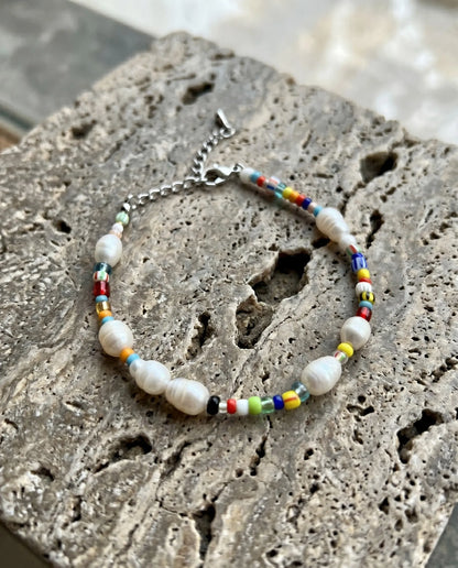 Korean handmade real freshwater pearl bracelet with rainbow Miyuki seed beads surgical steel lobster clasp on stone surface