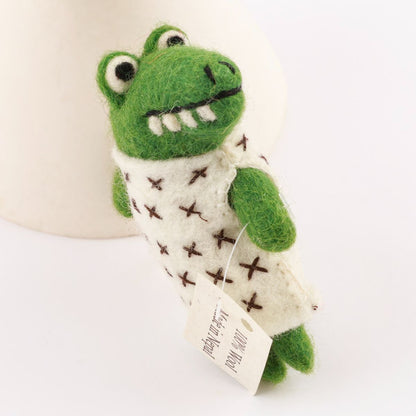 Green plush toy with a white scarf on a white background