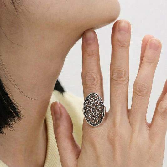 Woman wearing 925 sterling silver vintage filigree oval ring on index finger