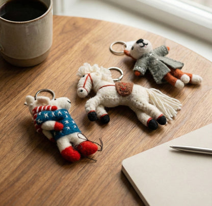 Handmade wool felt animal keychains set with horse raccoon and mouse on wooden desk