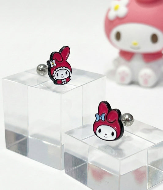 My Melody barbell stud earrings with surgical steel posts displayed on clear acrylic blocks