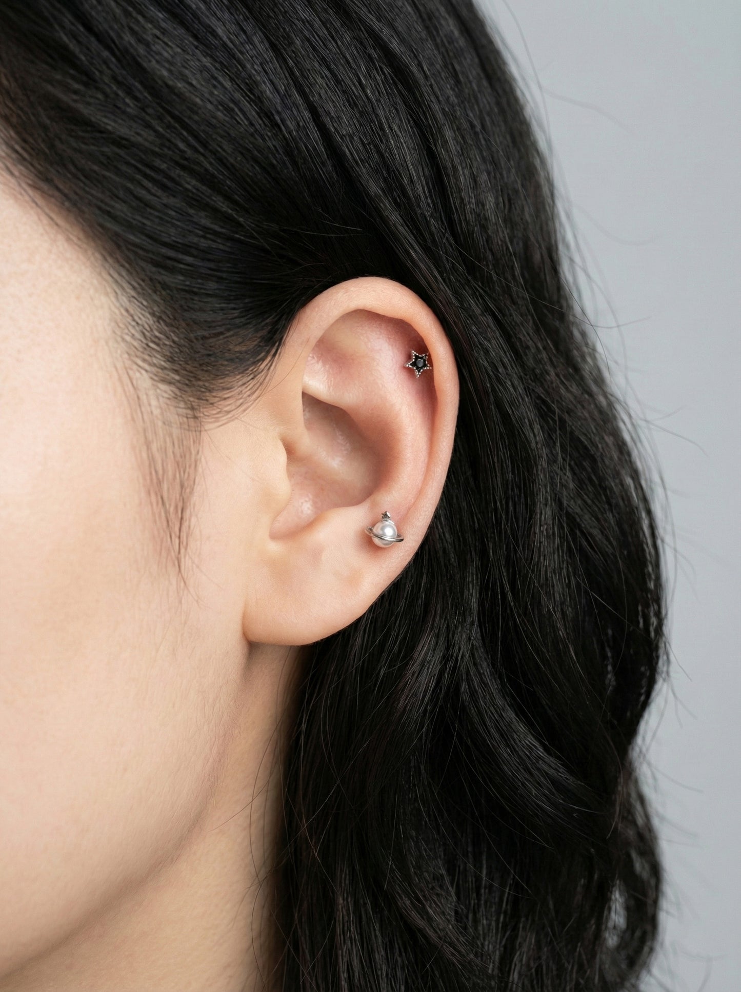 saturn planet pearl orbit barbell piercing worn on helix cartilage with star detail in silver finish