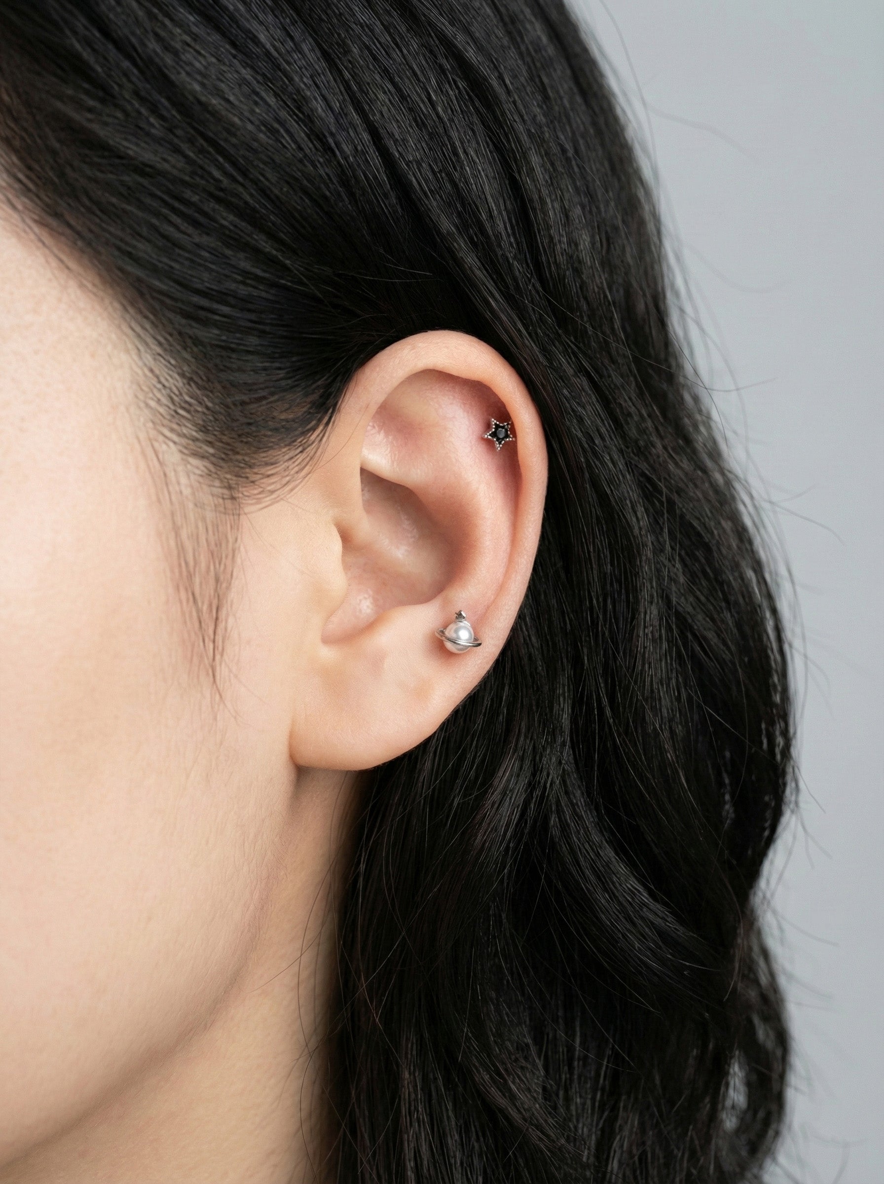 saturn planet pearl orbit barbell piercing worn on helix cartilage with star detail in silver finish