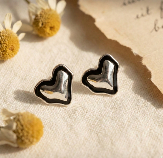 925 sterling silver black enamel organic heart stud earrings flat lay with dried flowers on linen fabric