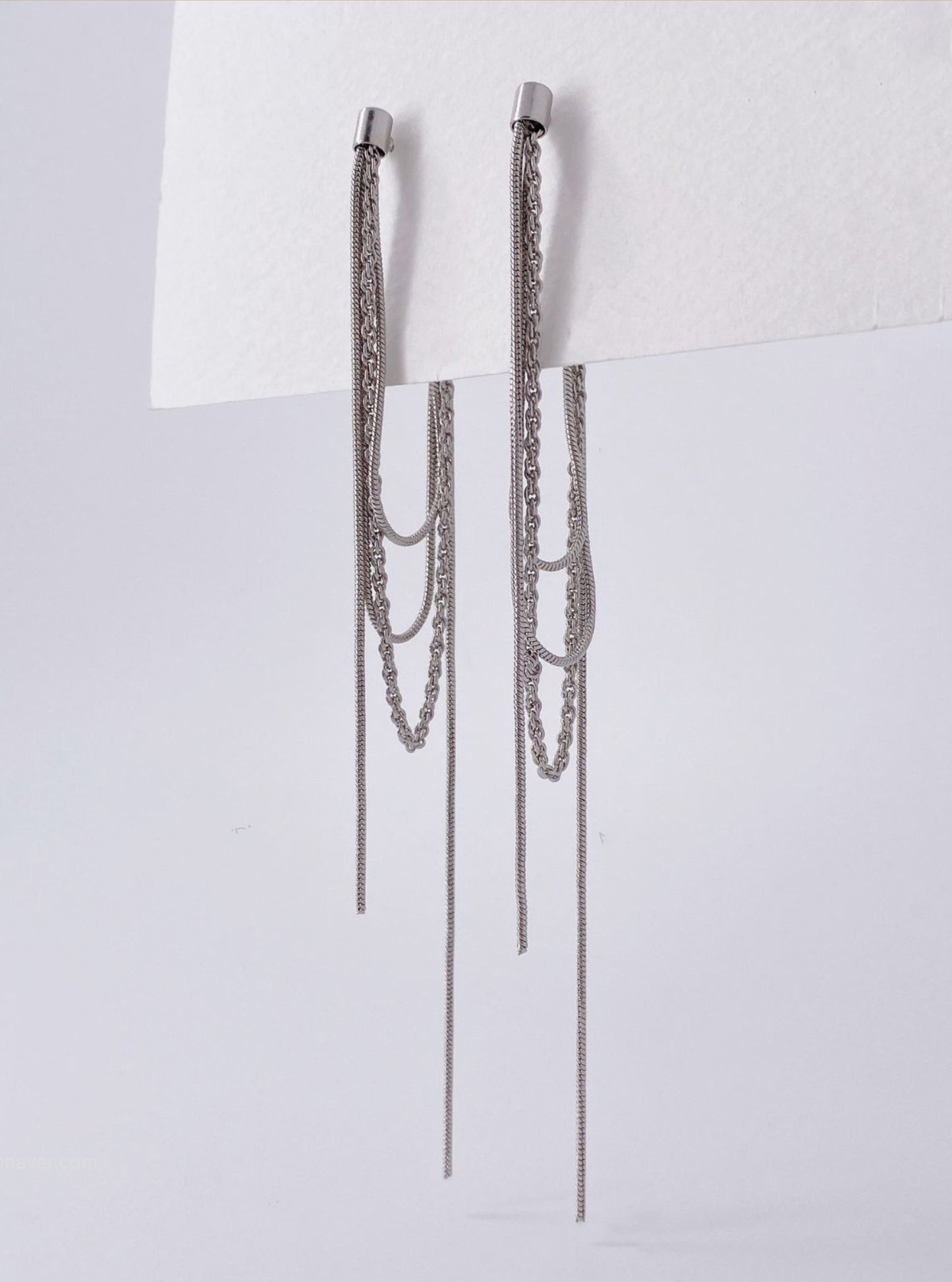 Silver layered front and back long chain drop earrings flat lay on white background