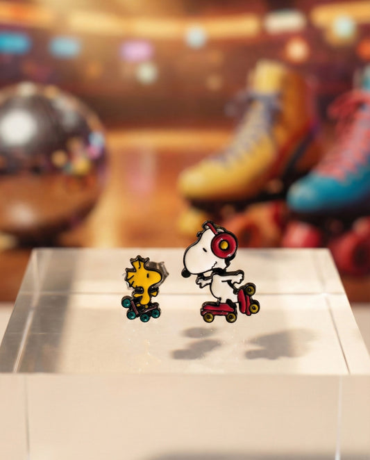 Handmade Snoopy and Woodstock roller skate earring set with headphones displayed on white earring card