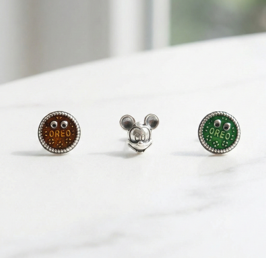 Three surgical steel character piercings with 925 silver posts - brown Oreo cookie, vintage Mickey Mouse, and green Oreo cookie with googly eyes