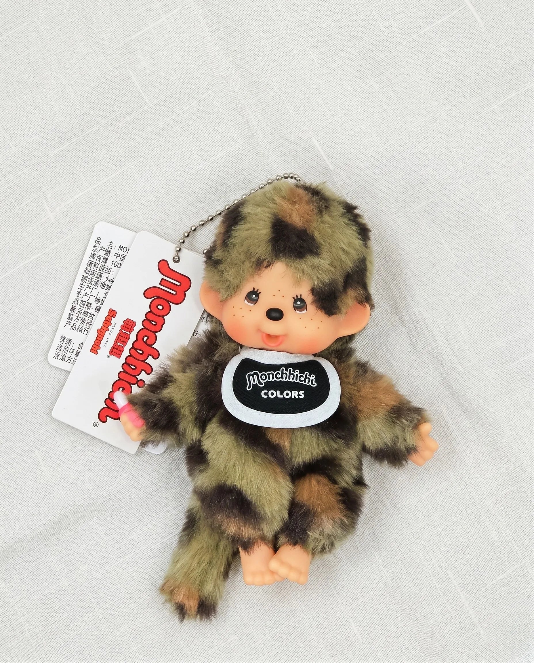 Flat lay product shot — Camo plush doll bag charm keychain 8ttitto8, Y2K streetwear aesthetic for backpack and bag decoration.