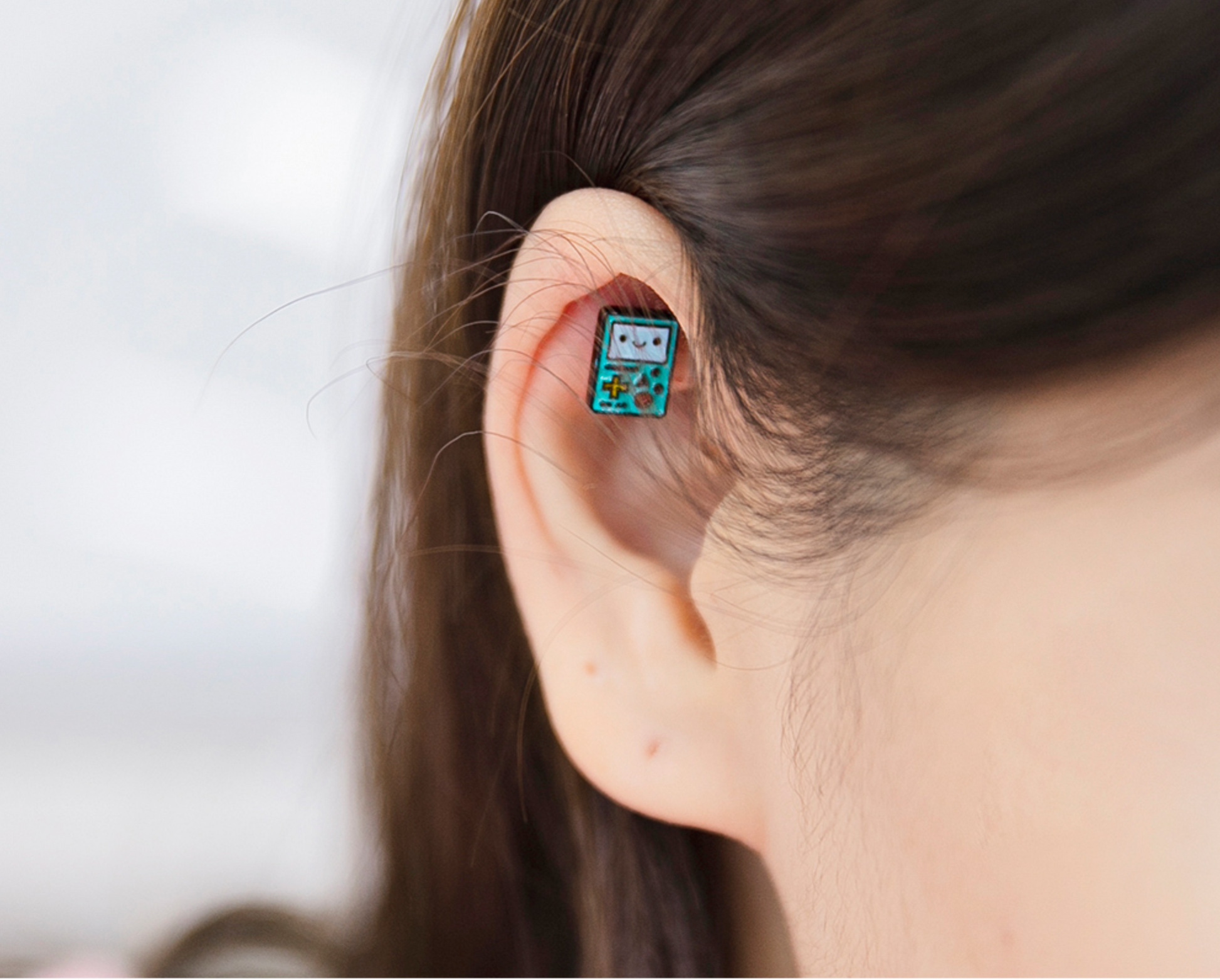 Adventure Time BMO enamel barbell earring styled on the inner ear, shaped like a retro game console