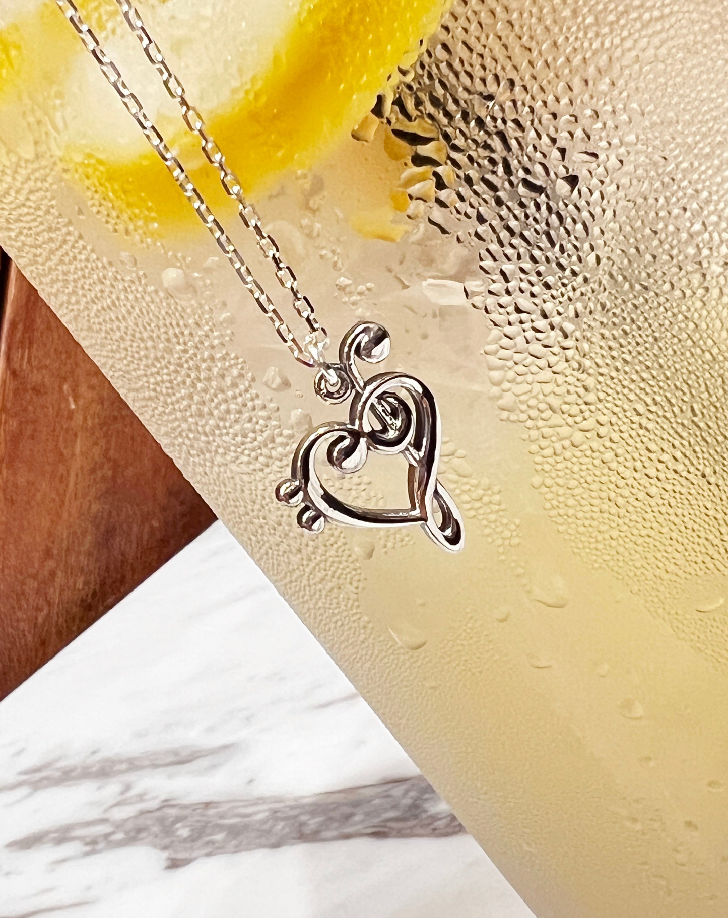 Heart-shaped music note pendant close-up detai