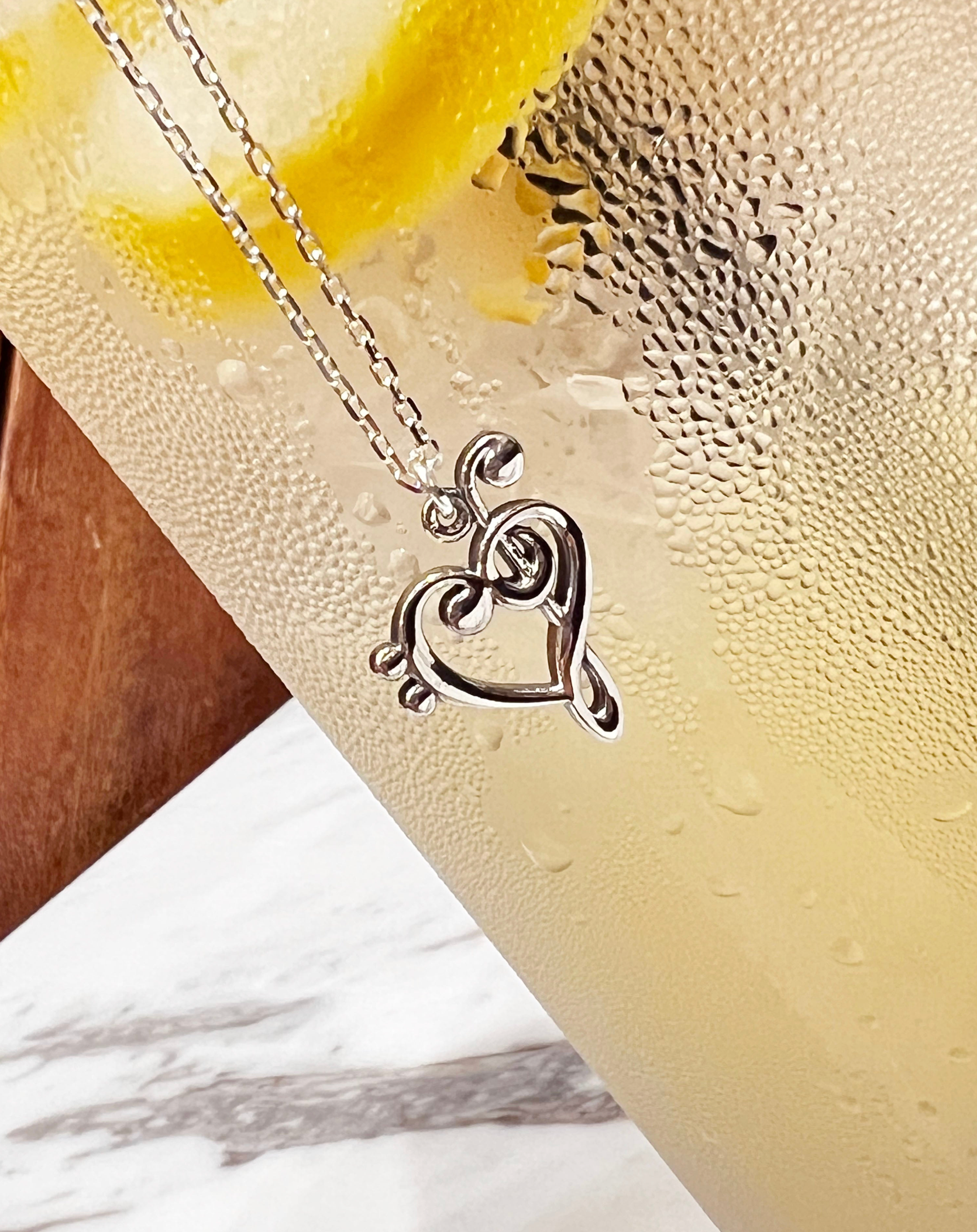 Heart-shaped music note pendant close-up detai