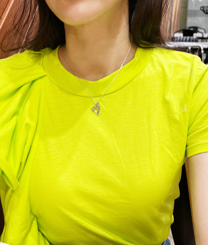 Heart treble clef necklace worn solo on model
