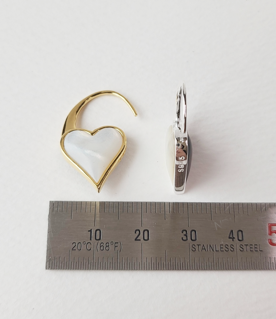 Heart-shaped hook earring in gold with white mother-of-pearl shown next to a steel ruler for size reference (approx. 30mm).