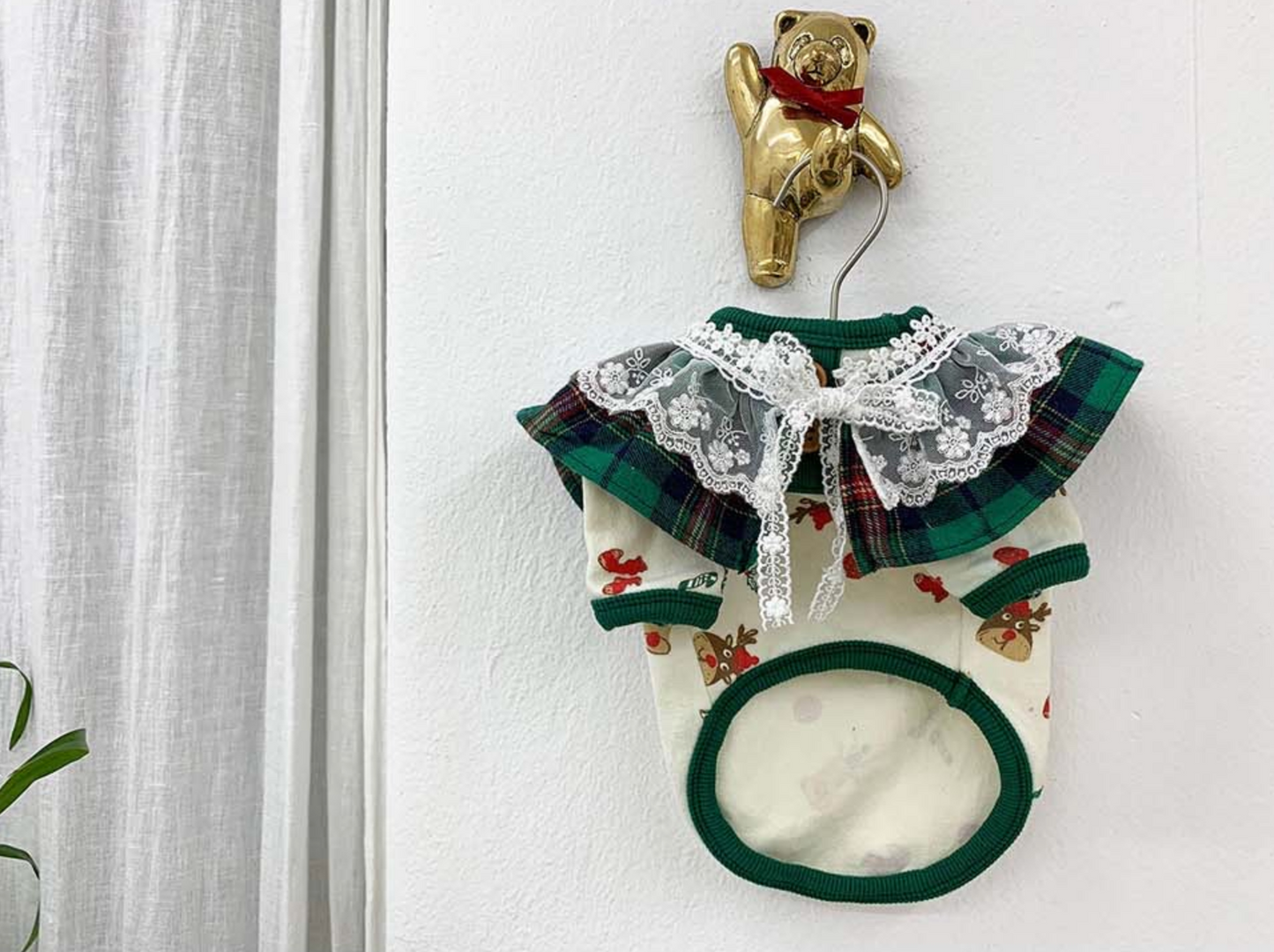 Green plaid dog shirt with lace collar, front view
A green tartan holiday pet shirt featuring white embroidered lace trim and ribbon detail, made for small dogs.