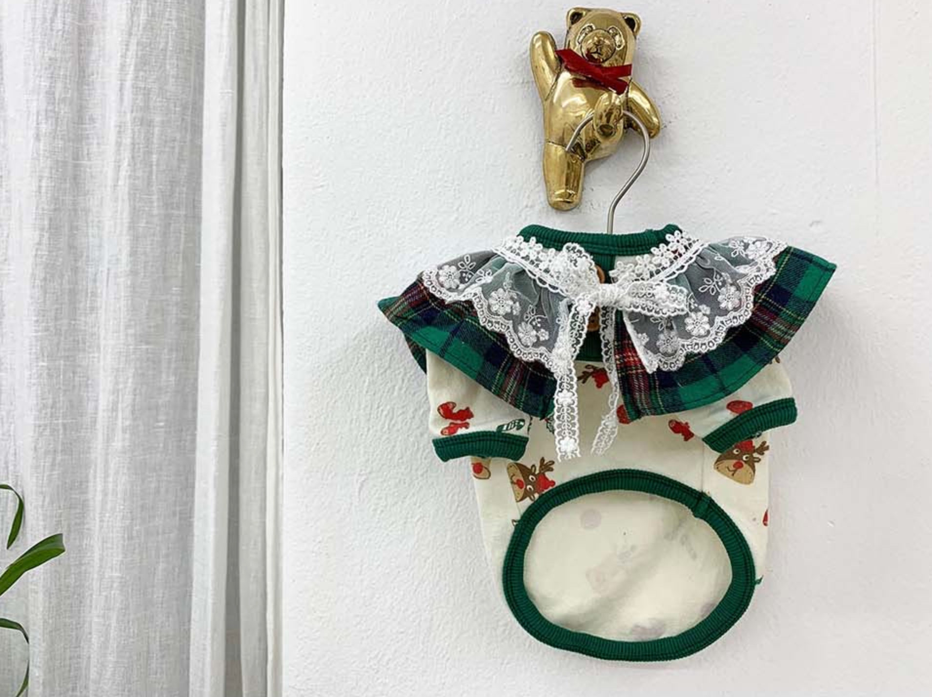 Green plaid dog shirt with lace collar, front view
A green tartan holiday pet shirt featuring white embroidered lace trim and ribbon detail, made for small dogs.