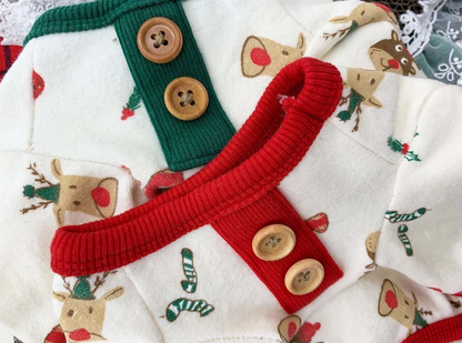Close-up view of a cream-colored Christmas dog shirt with reindeer, candy cane, and mitten patterns. Features green and red ribbed collars with wooden buttons.