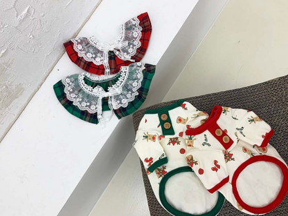 Two holiday dog lace collars and matching reindeer print shirts in red and green trim, arranged for gift styling.