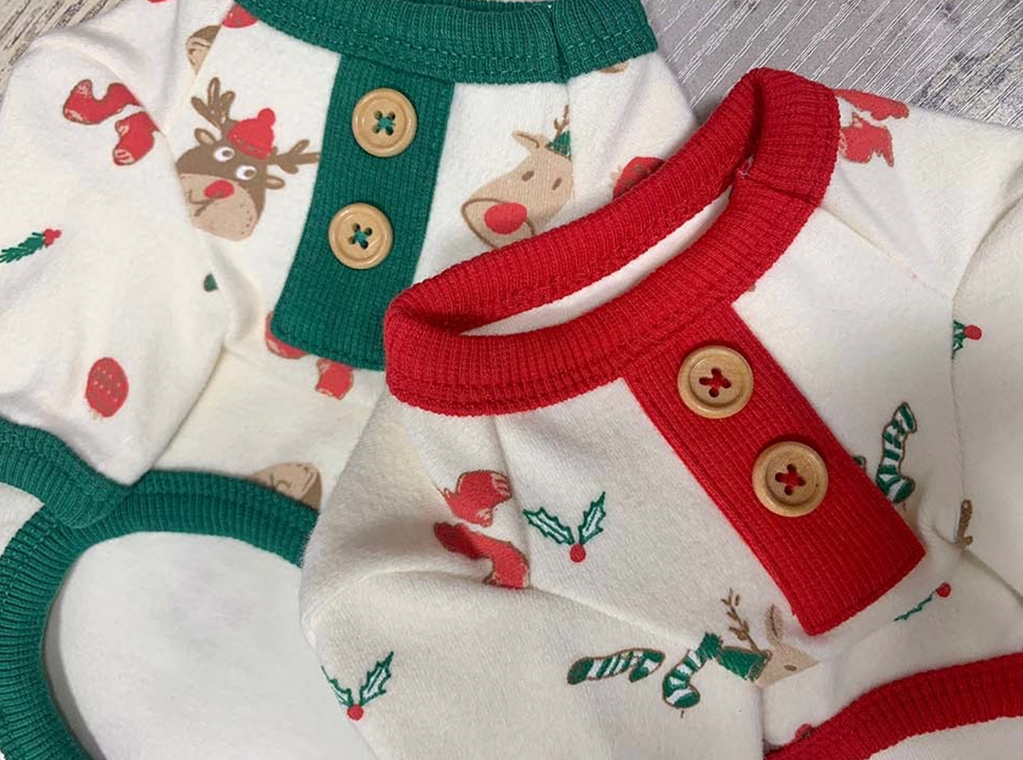Zoomed-in detail of the red and green button placket on each dog shirt. Features playful reindeer, holly, and holiday sock prints on warm cotton fabri