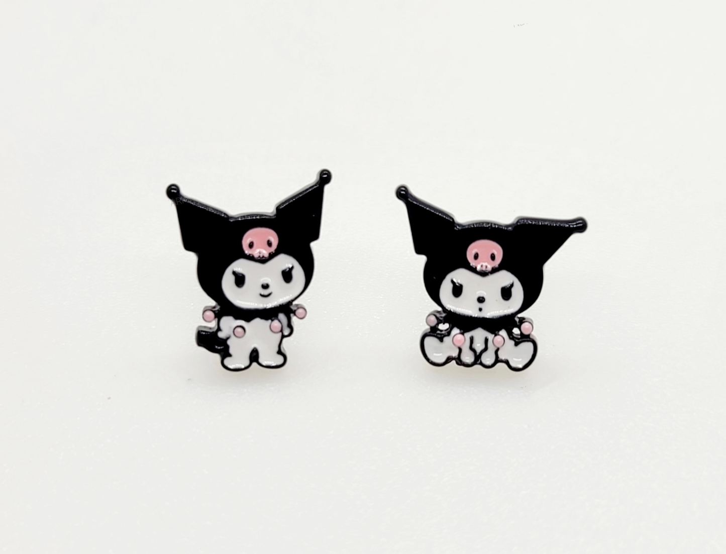 Pair of Kuromi enamel stud earrings on white background, featuring two distinct poses with pink skull accents.