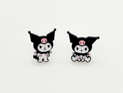 Pair of Kuromi enamel stud earrings on white background, featuring two distinct poses with pink skull accents.