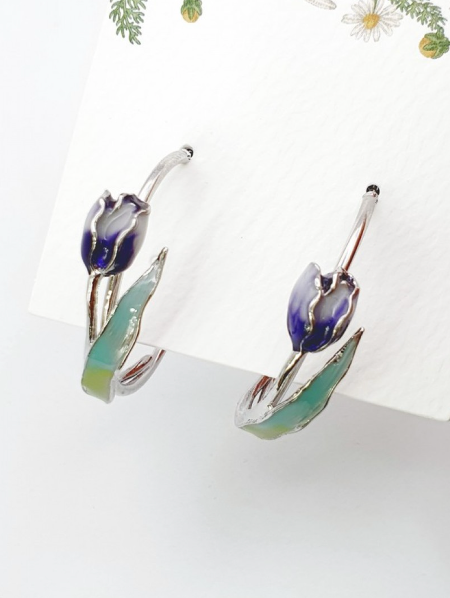 Flat lay of blue gradient tulip hoop earrings with enamel coating