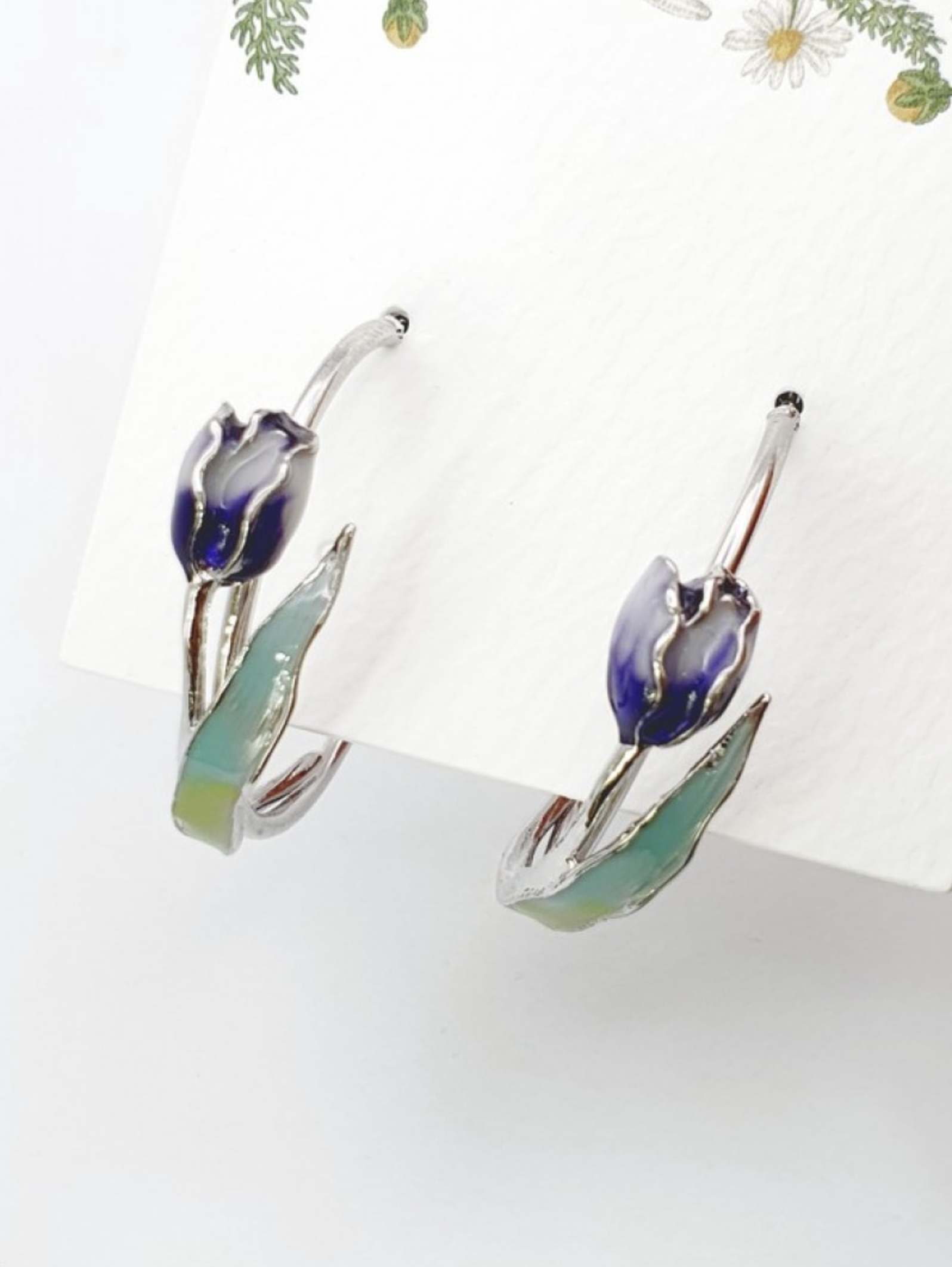 Flat lay of blue gradient tulip hoop earrings with enamel coating