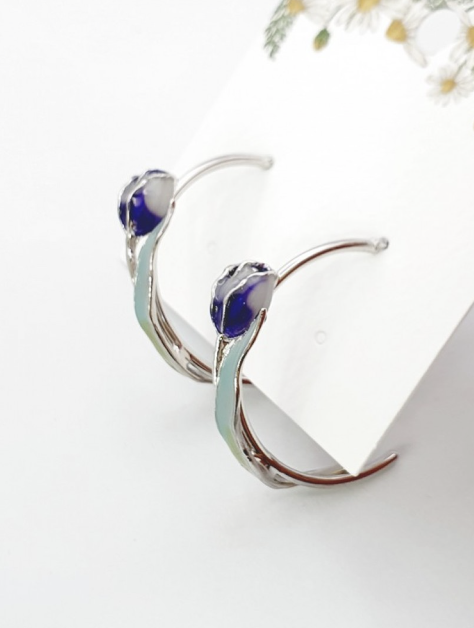 Close-up view of blue and pink watercolor tulip hoop earrings showing gradient detail