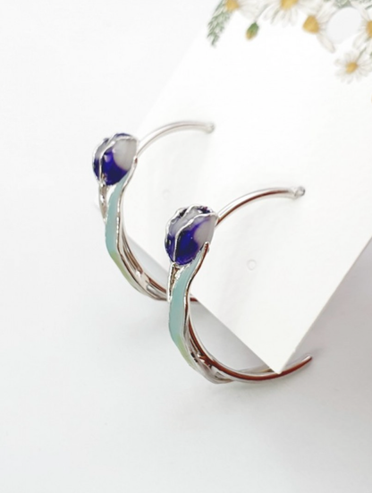 Close-up view of blue and pink watercolor tulip hoop earrings showing gradient detail