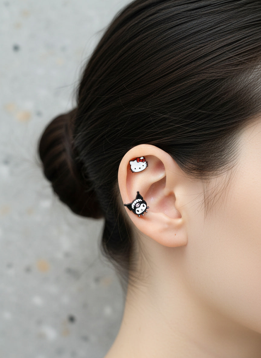 Hello Kitty and Kuromi surgical steel cartilage piercing studs layered on ear