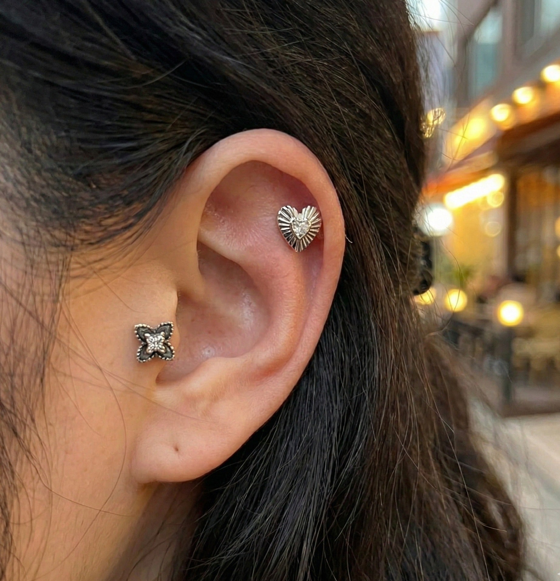 Side view of layered ear stack with radiant heart on helix and quatrefoil flower on conch