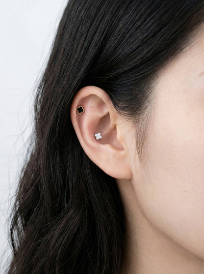 Black and white mother of pearl clover piercings with titanium posts mixed in cartilage and conch ear styling