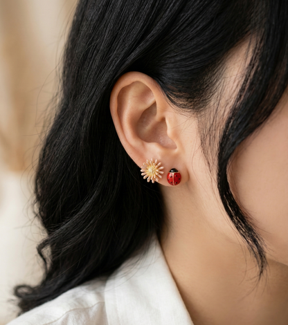 Close-up of a model wearing the Retro Red set, featuring a pink daisy and a red ladybug stud earring.
