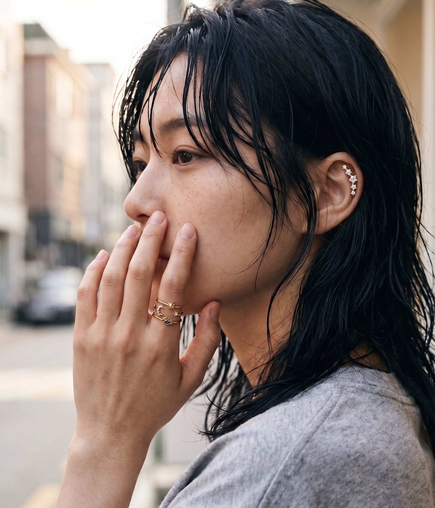Seoul street style aesthetic model wearing gold celestial evil eye layered ring with star CZ ear piercing, K-fashion inspo daily look.