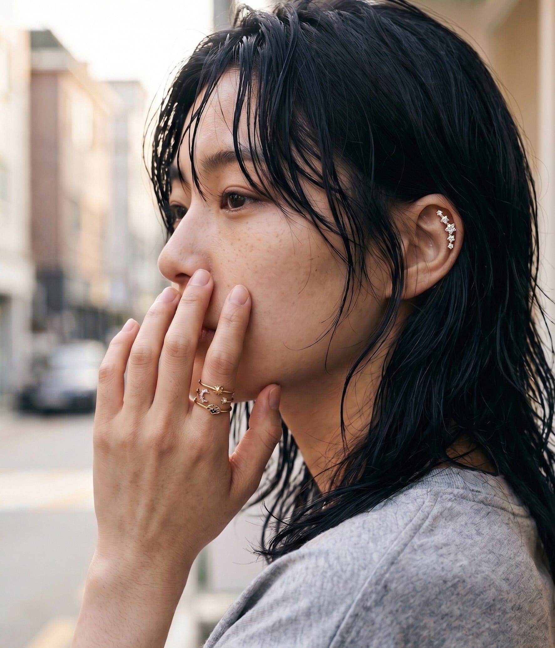 Seoul street style aesthetic model wearing gold celestial evil eye layered ring with star CZ ear piercing, K-fashion inspo daily look.