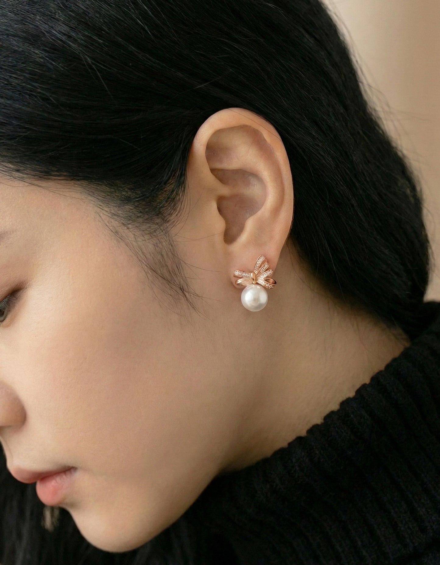 Rose gold ribbon bow pearl earrings on ear, Korean handmade jewelry close-up