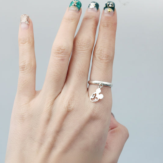 Solid silver Mickey charm ring on middle finger with decorative nail art, showing premium quality jewelry styling
