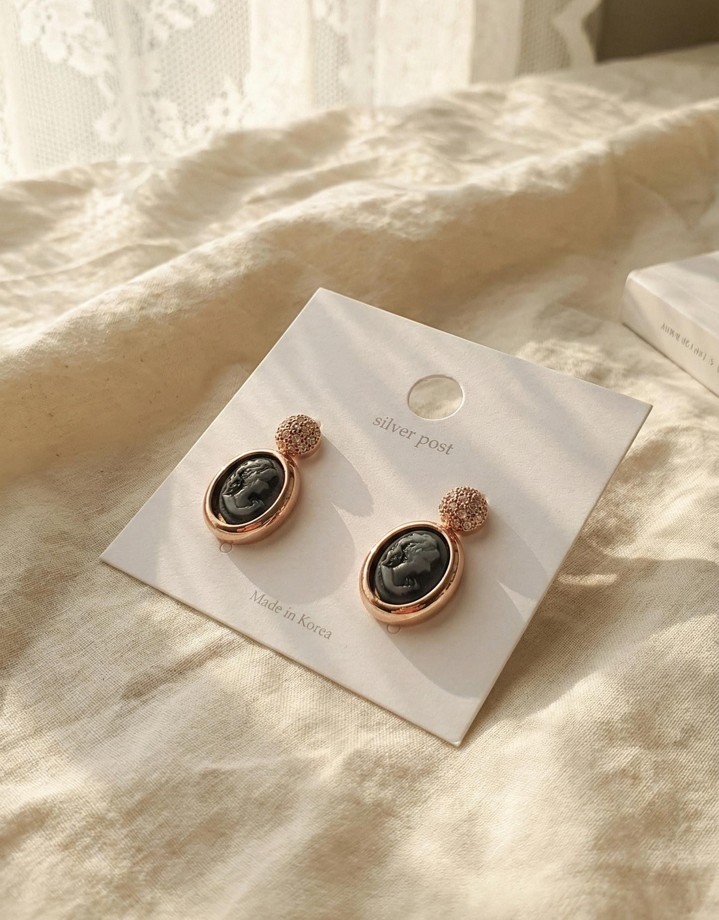 Rose gold cameo earrings with 925 sterling silver posts packaging on linen fabric