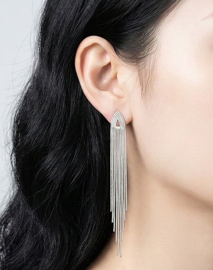 Close-up of extra long silver tassel earrings cascading down to collarbone, titanium post hypoallergenic jewelry