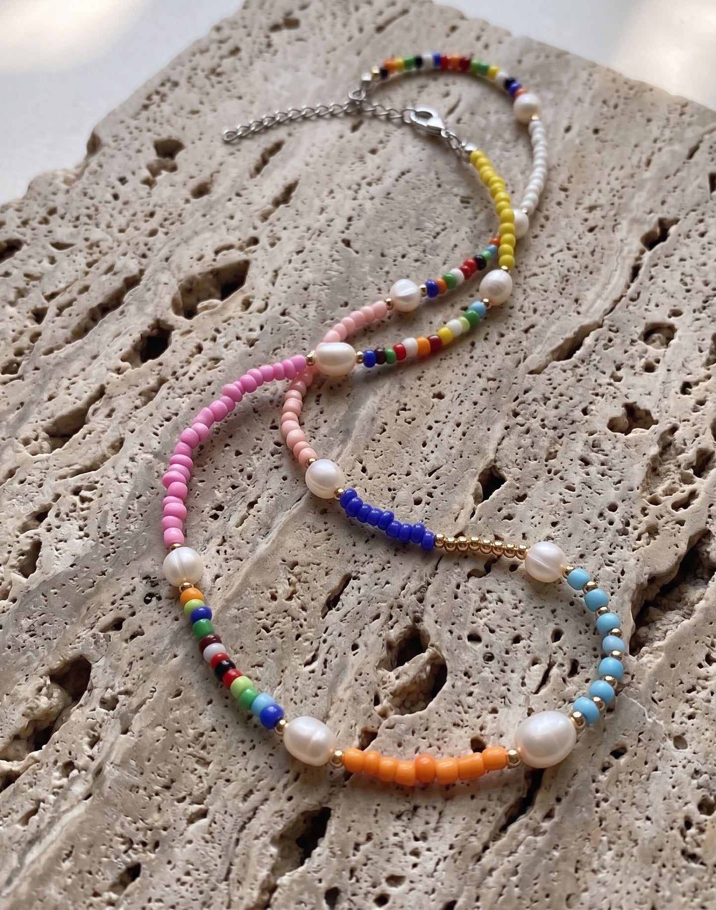 Multicolor beaded necklace flatlay all colorways rainbow pink blue gold freshwater pearl layered necklace set.