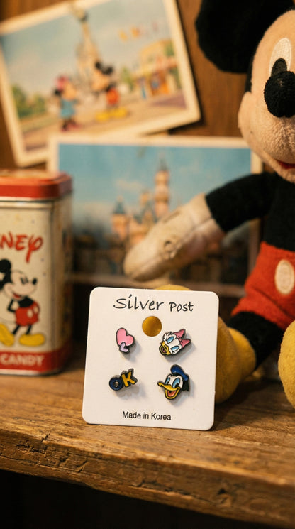 Donald and Daisy Duck enamel earring set displayed with vintage Disney collectibles on wooden surface