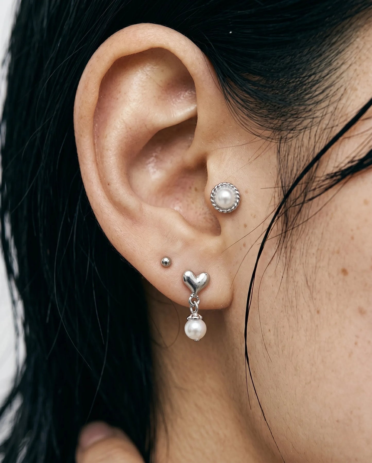 close up of vintage pearl conch piercing layered with chunky heart drop pearl earring on lobe – pearl piercing stack by 8ttitto8