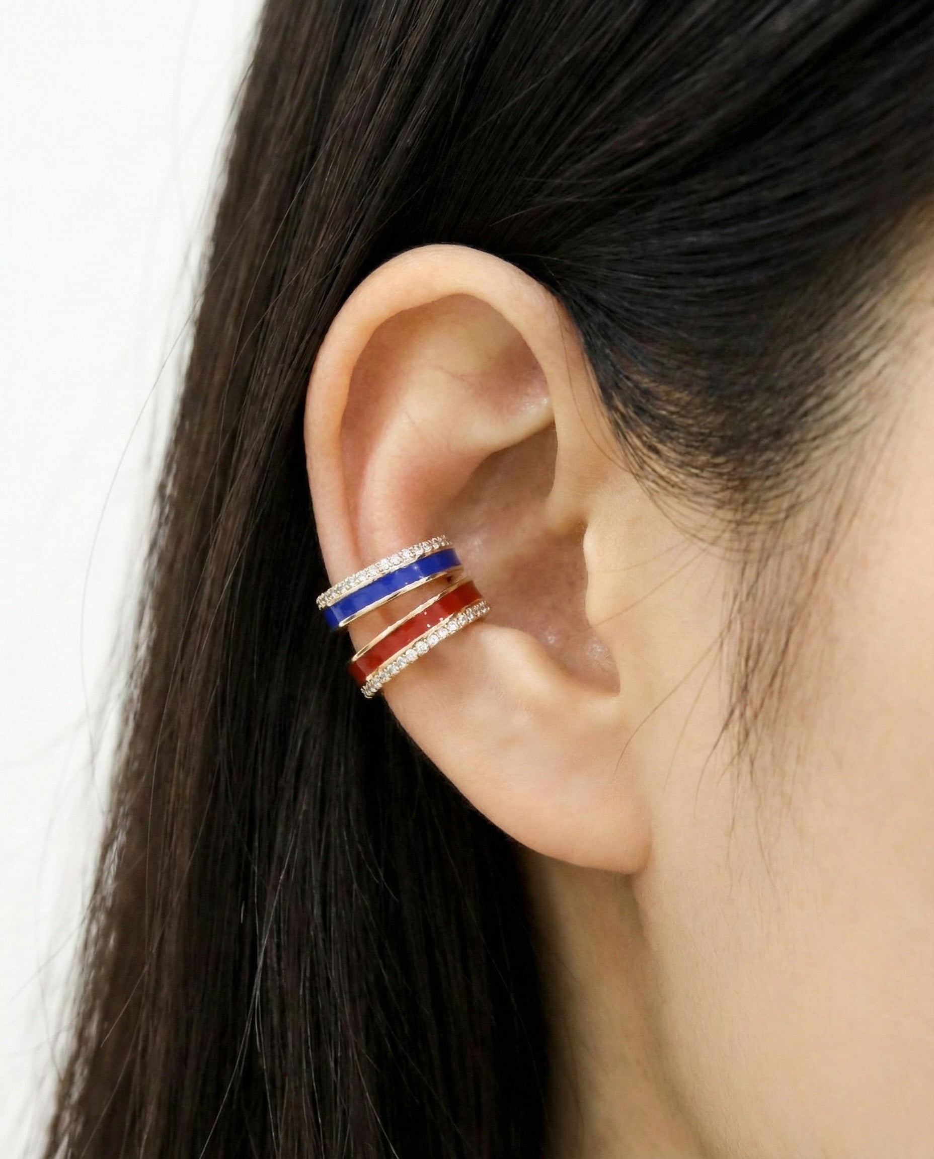 Triple-layer ear cuff with red enamel, blue enamel, and cubic zirconia rows, worn on upper ear