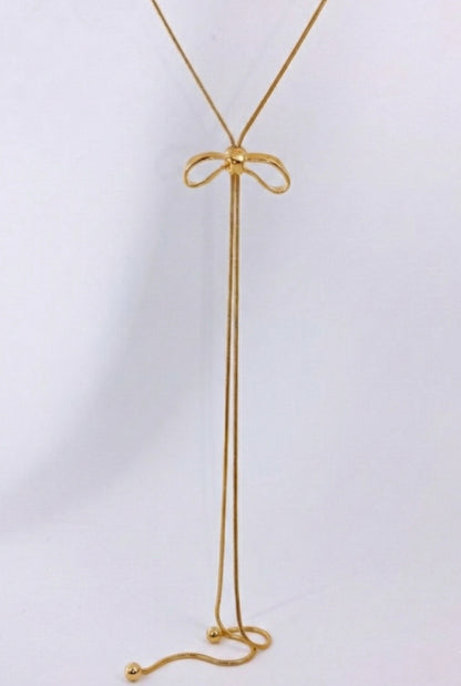 Close-up of gold ribbon bow pendant with sliding mechanism - 65cm adjustable lariat necklace