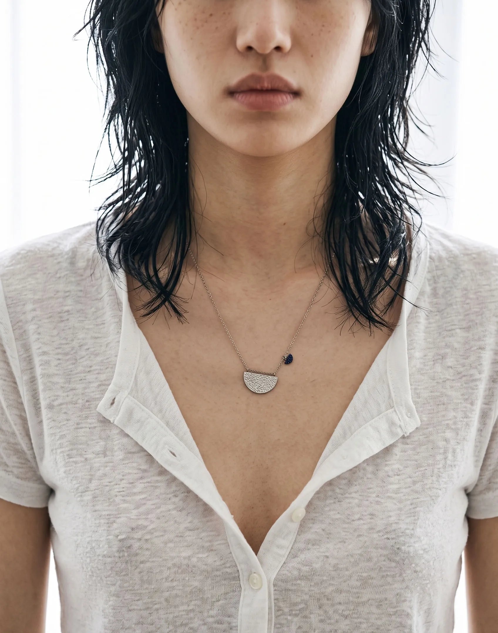Model neckline crop, cream shirt — Minimalist silver necklace inspo featuring hammered half-moon pendant, hypoallergenic 925 silver.
