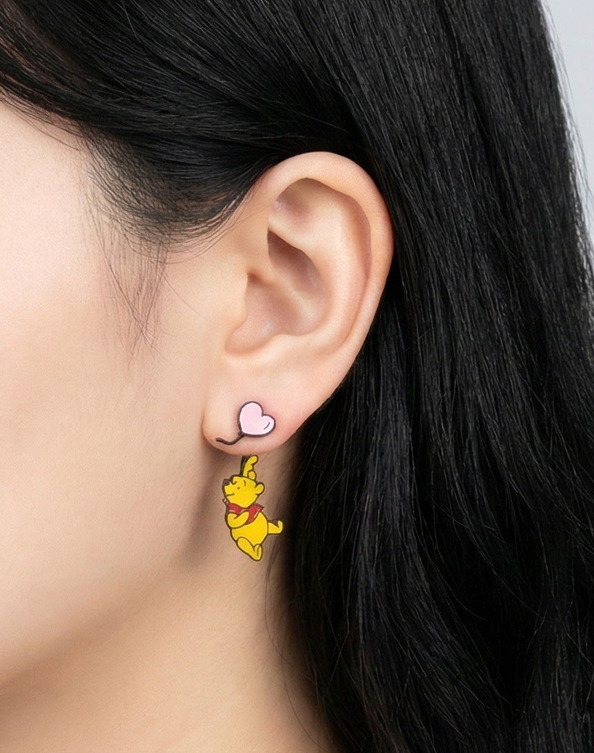 Pink balloon bear earring on ear, character dangling playfully from heart-shaped stud