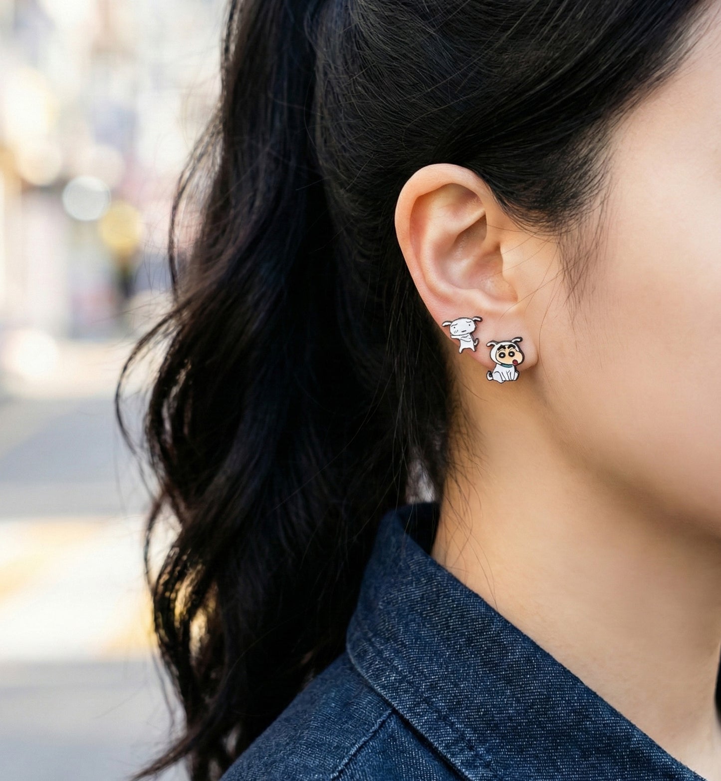 Woman wearing Crayon Shin-chan and Shiro asymmetrical earrings with denim jacket, casual K-fashion style
