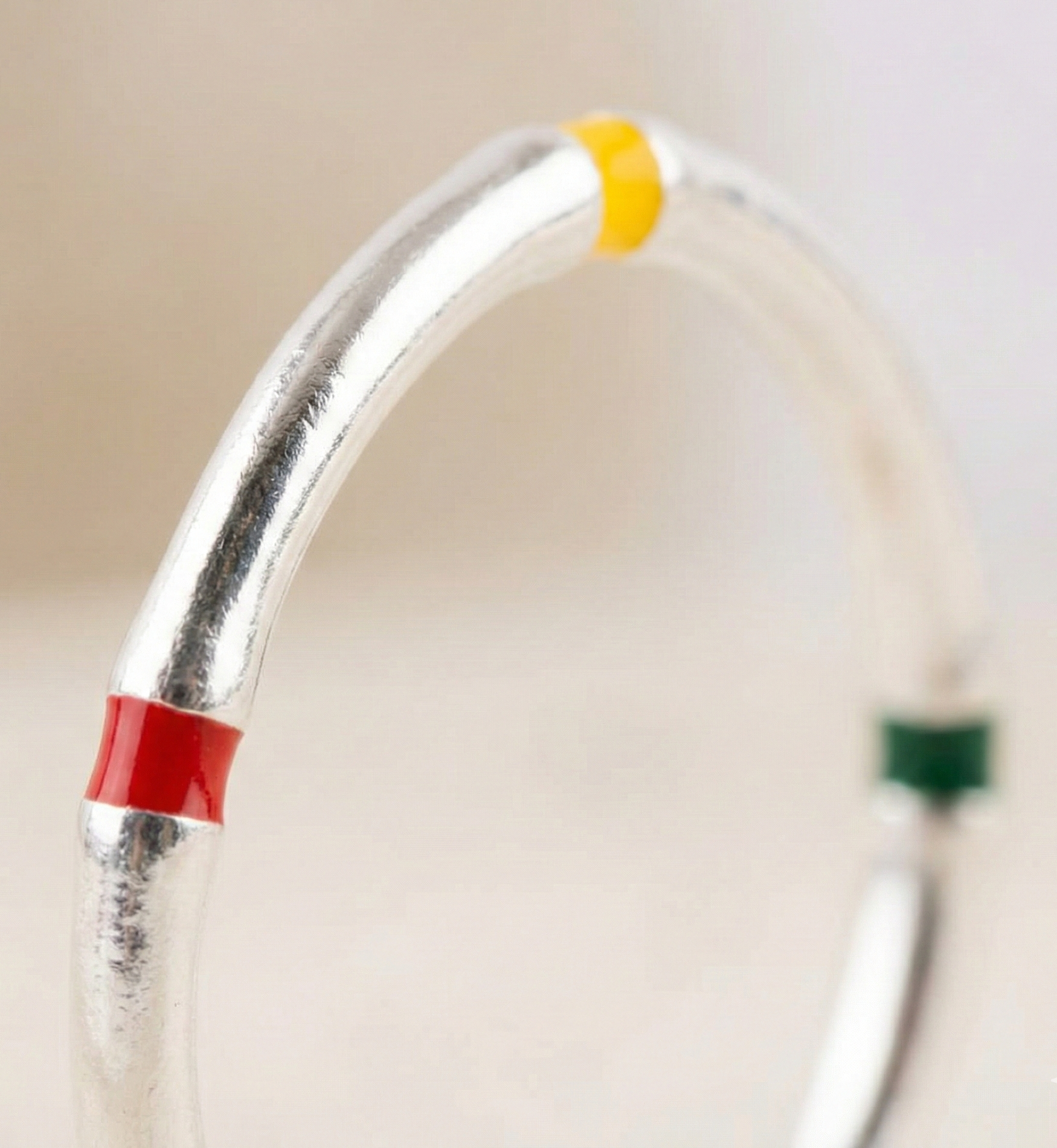 Close-up macro shot of 925 silver enamel stackable ring highlighting vivid red, yellow, and green enamel block details on polished silver band