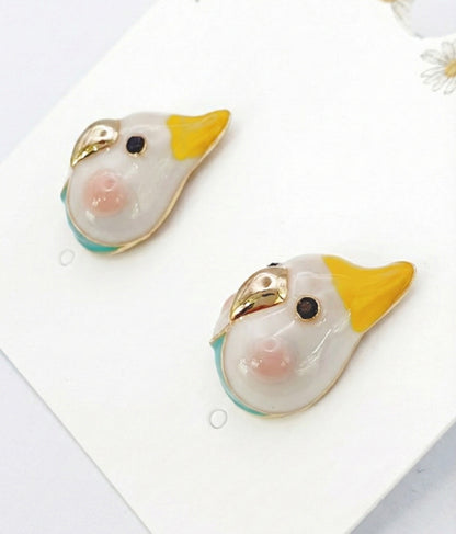  Close-up of white cockatiel earring pair with yellow crest, gold beak and turquoise accent 