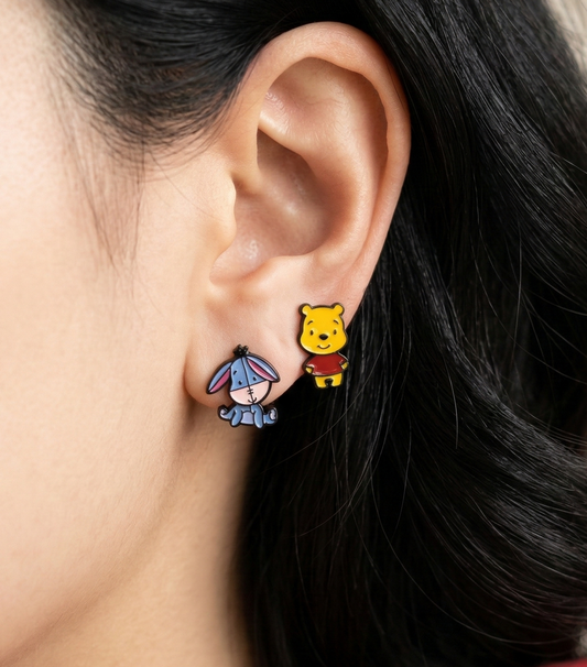 Woman wearing Winnie the Pooh and Eeyore character stud earrings