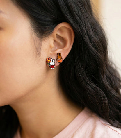 Close-up of woman wearing cute Miffy flower bunny and Melanie rabbit character earrings, kawaii asymmetric stud earrings